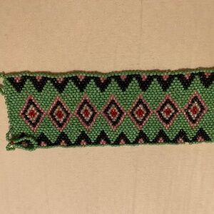 Handmade Huichol-style seed bead bracelet featuring green, black, pink & red.